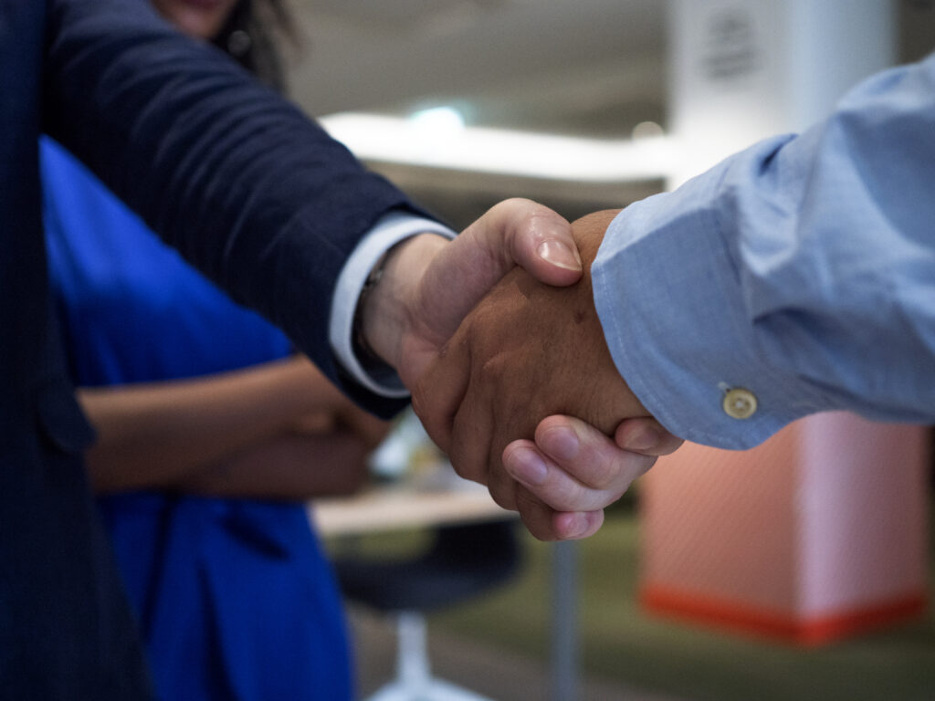 A bag-in-box employee from General Films shakes hands with a happy client.